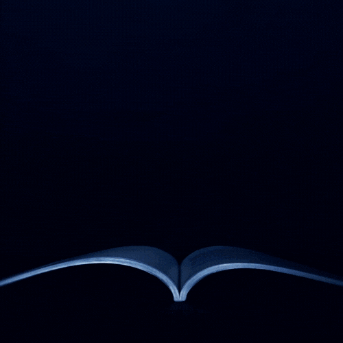 A book is open in the dark with its pages lit up.