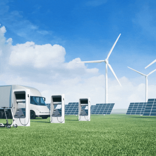 A van and some wind turbines in the grass.